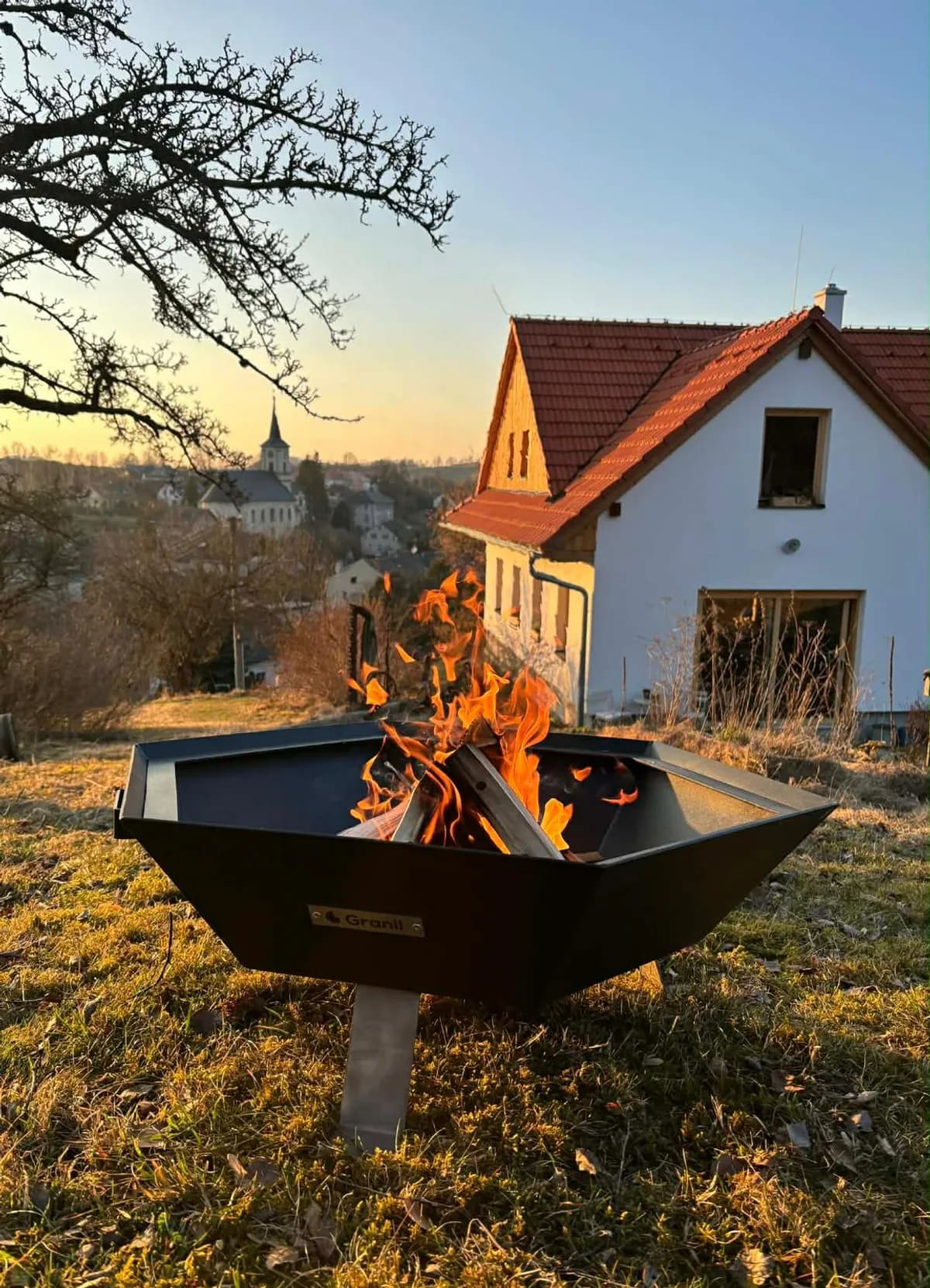 Ohniště GRANIL Hexagon Go — zapálené v zahradě